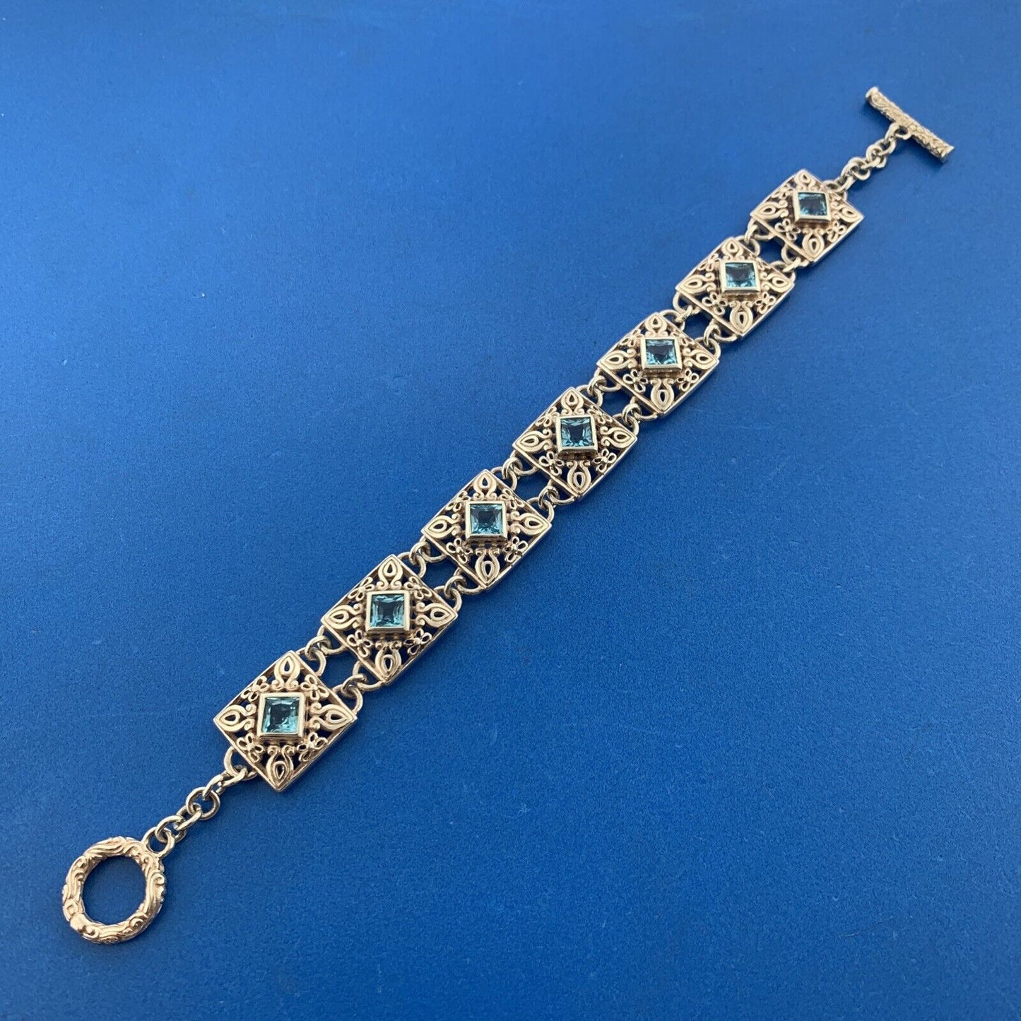 Designer NF Sterling Silver Square Blue Topaz Open Scroll Toggle Tennis Bracelet