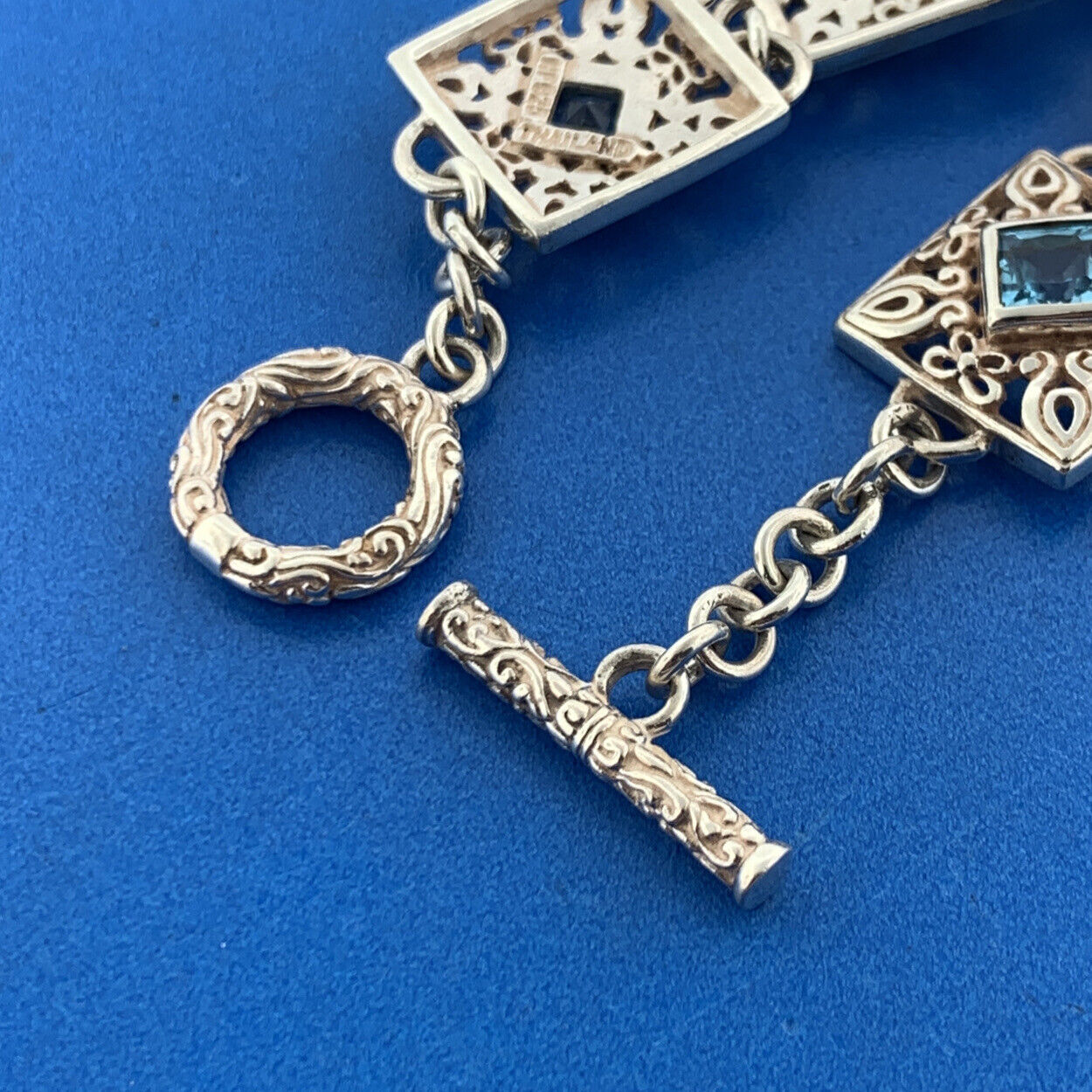 Designer NF Sterling Silver Square Blue Topaz Open Scroll Toggle Tennis Bracelet
