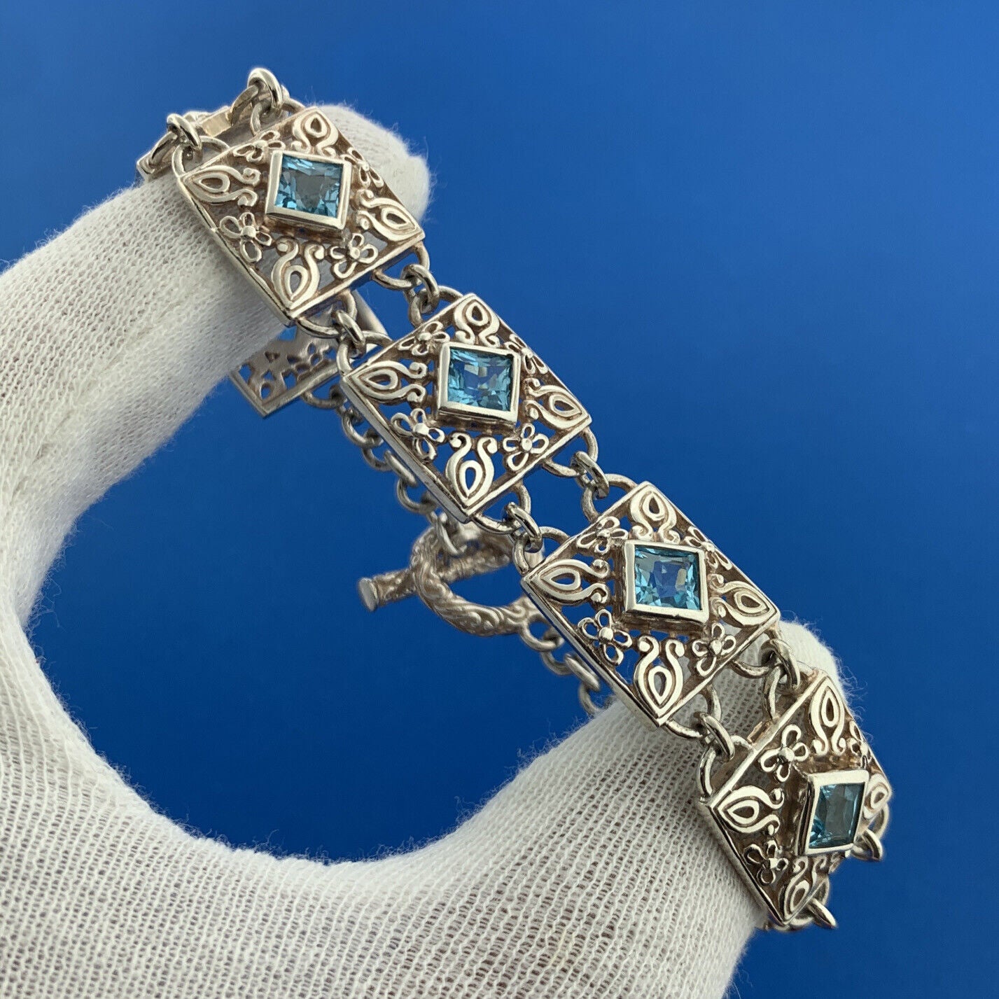 Designer NF Sterling Silver Square Blue Topaz Open Scroll Toggle Tennis Bracelet